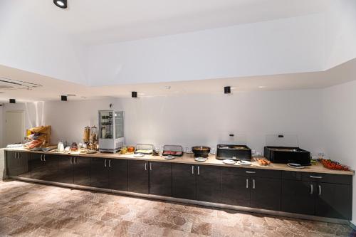 a large kitchen with a long counter in a room at Johann Strauss Hotel in Bucharest