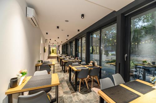 a row of tables and chairs in a restaurant with windows at Johann Strauss Hotel in Bucharest