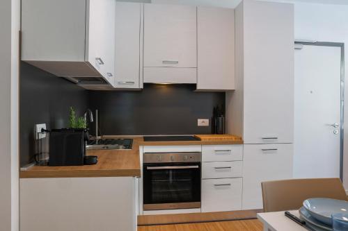 a white kitchen with white cabinets and a sink at Spina Verde Palazzo in Cavallasca