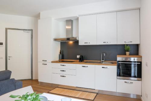 a kitchen with white cabinets and a table at Spina Verde Palazzo in Cavallasca