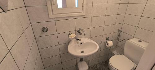 a bathroom with a sink and a toilet at Διαμέρισμα στο Ρίο Πατρών in Rio