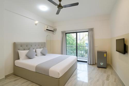 a bedroom with a large bed and a window at T0MS H0LiDAYS HOMES G0A in Calangute