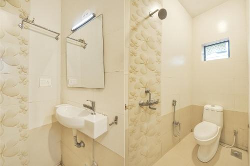 a white bathroom with a sink and a toilet at T0MS H0LiDAYS HOMES G0A in Calangute