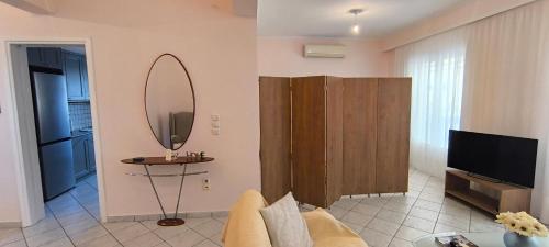 a living room with a couch and a mirror at Διαμέρισμα στο Ρίο Πατρών in Rio