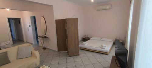 a living room with a bed and a couch at Διαμέρισμα στο Ρίο Πατρών in Rio