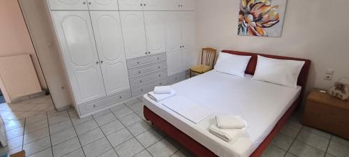 a bedroom with a white bed with two towels on it at Διαμέρισμα στο Ρίο Πατρών in Rio