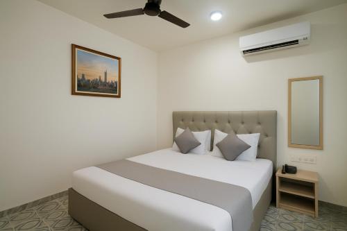 a bedroom with a white bed and a ceiling fan at T0MS H0LiDAYS HOMES G0A in Calangute
