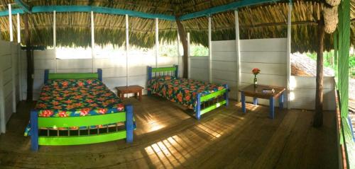 a room with two beds and a table and a tableasteryasteryasteryasteryastery at Reserva Natural Viento Solar in Cedro