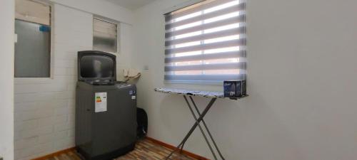 a room with a small television and a table with a small refrigerator at Casa Turismo Freirina in Freirina