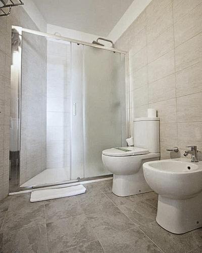 a bathroom with a shower and a toilet and a sink at Hotel Niagara in Lido di Jesolo
