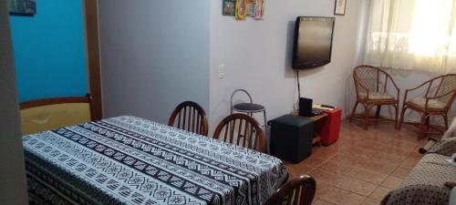 Habitación con cama, TV y sillas. en Apto familiar no Guarujá, próximo da Praia das Astúrias, en Guarujá