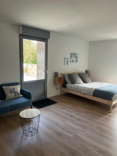 a bedroom with a bed and a couch and a window at Grange de Courbey in Chambornay-lès-Pin