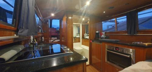 a kitchen with a sink and a stove in a boat at Unieke overnachting op een boot in Giethoorn in Giethoorn