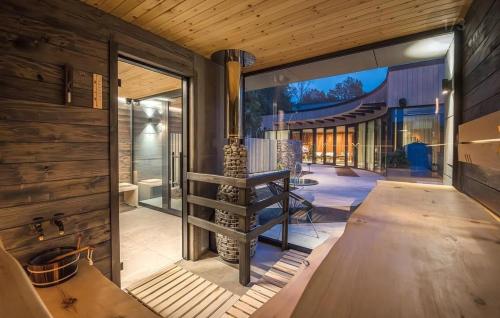 a house with a large glass door and a fireplace at Albatross Apartment Sea in Ķesterciems