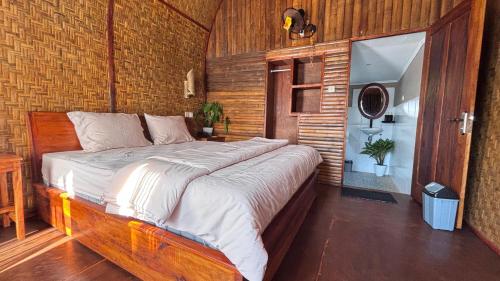 a bedroom with a large bed and a brick wall at Tetebatu flower in Tetebatu