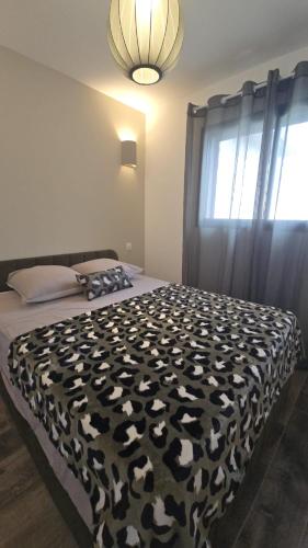 a bedroom with a black and white bed with a window at Appartement T2 moderne 2 à 4 personnes in Lucciana