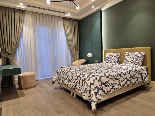 une chambre avec un lit, un bureau et des fenêtres dans l'établissement Serenity Lodge Residencia, à Islamabad