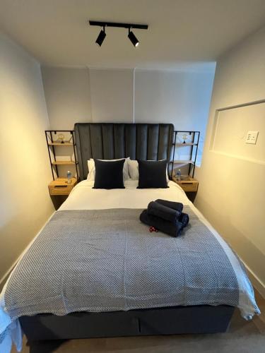 a bedroom with a large bed with a black headboard at Tokapa, a place between worlds in Cape Town