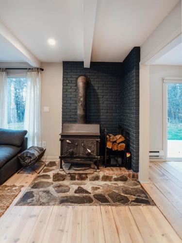 a living room with a brick fireplace with a stove at Catskill MNTN Escape 5 BR 3 bath Villa Hot Tub Fire Pit Best Group Stay in Prattsville