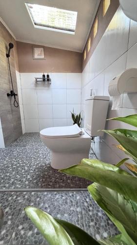 a bathroom with a toilet and a plant at Tetebatu flower in Tetebatu
