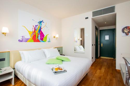 a bedroom with a white bed with a tray on it at AN Hotel Milano San Donato in San Donato Milanese