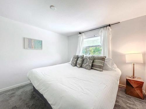 a bedroom with a white bed and a window at New Beautiful Seminole Pool Home in Seminole
