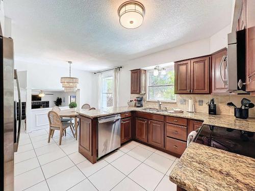 a large kitchen with wooden cabinets and a table at New Beautiful Seminole Pool Home in Seminole