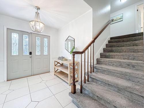 a hallway with stairs and a door with a chandelier at New Beautiful Seminole Pool Home in Seminole