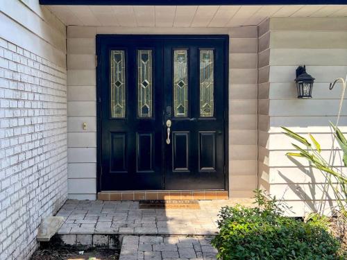 a black door on a house with a brick wall at New Beautiful Seminole Pool Home in Seminole