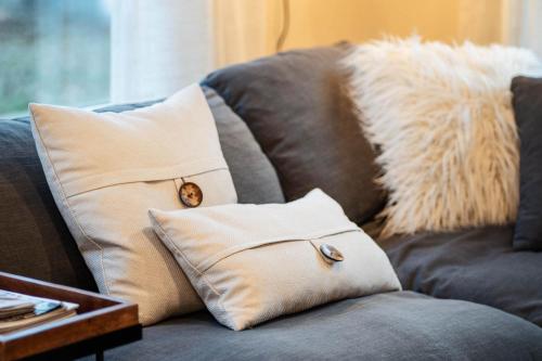 a couch with two pillows with a dog sticking its head out at Catskill MNTN Escape 5 BR 3 bath Villa Hot Tub Fire Pit Best Group Stay in Prattsville