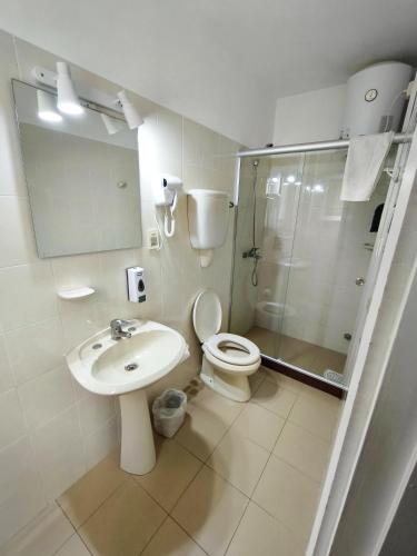 a bathroom with a toilet and a sink and a shower at Hotel Romi in Colonia del Sacramento