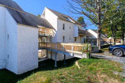 a house with a deck and a car parked in a driveway at Bridges 19 condo in Sugarbush Village