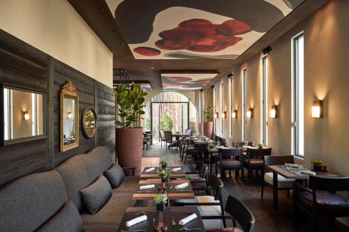 a restaurant with couches and tables and chairs at L'Isle de Leos Hotel & Spa - MGallery Collection in LʼIsle-sur-la-Sorgue