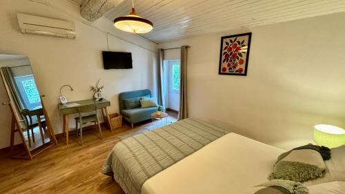 a bedroom with a bed and a desk and a chair at Hotel Le Galambre in Nîmes