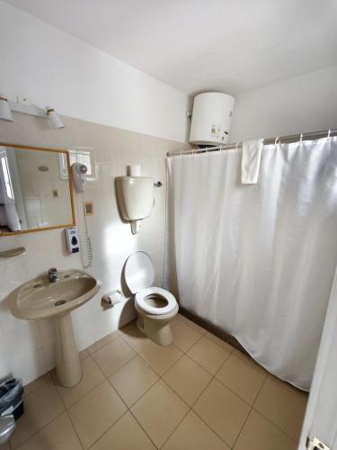 a bathroom with a toilet and a sink at Hotel Romi in Colonia del Sacramento