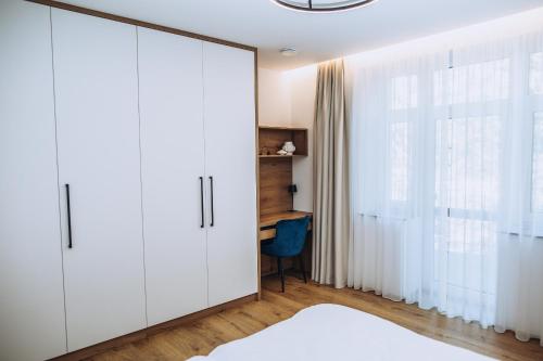 a bedroom with a large white closet and a desk at Apartmány Orlí in Hranice