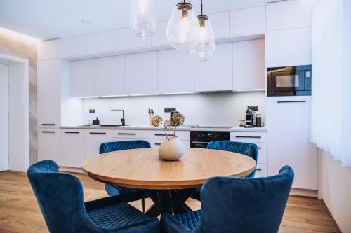 a kitchen with a wooden table and blue chairs at Apartmány Orlí in Hranice