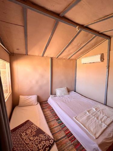 a small bedroom with two beds in a room at Happy Camp in Nuweiba
