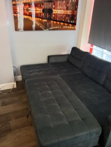 a large couch in a living room with a painting at Lower Cheltenham Place in Bristol