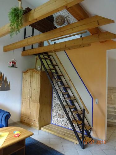 a wooden staircase in a living room with a loft at Ferienwohnung Hermannstein in Ilmenau