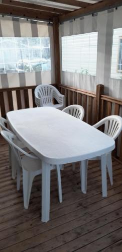 a white table and chairs in a room at MOBIL HOME CONFORT PLUS - 40m2 - 3ch - 2 SDB - Camping 4 étoiles - BONNE ANSE 56 in Les Mathes
