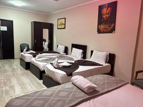 a group of four beds in a room at Comfort Sphinx & Pyramids Inn in Cairo