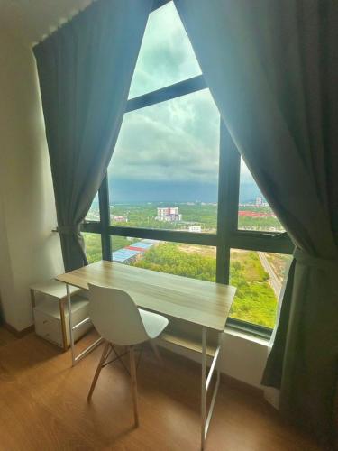 a table and a chair in front of a large window at imperium residence kuantan in Kuantan