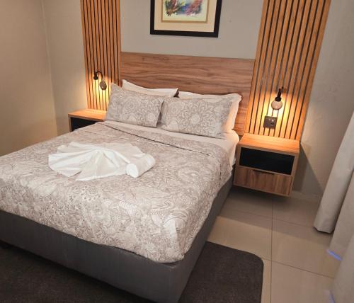 a hotel room with a bed with a robe on it at Sandown Suites and Conference Centre in Johannesburg