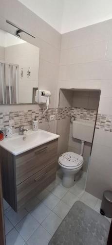 a bathroom with a sink and a toilet and a mirror at casa kiki in Pozzuoli