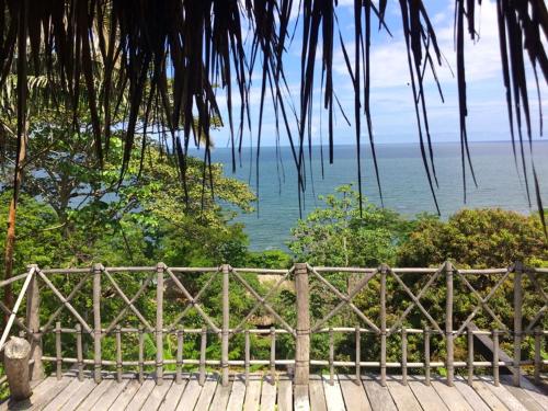 a wooden bench sitting on a deck looking at the ocean at Reserva Natural Viento Solar in Cedro