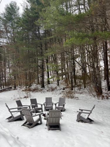 a group of chairs sitting in the snow at Catskill MNTN Escape 5 BR 3 bath Villa Hot Tub Fire Pit Best Group Stay in Prattsville