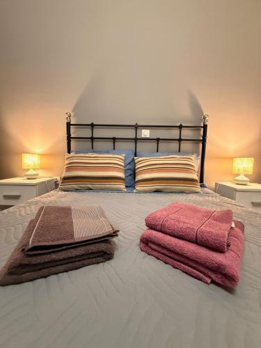 a bed with three towels on it with two lamps at WINDSOR PLACE APARTMENT - SELF CHECKIN with CODE in Athens