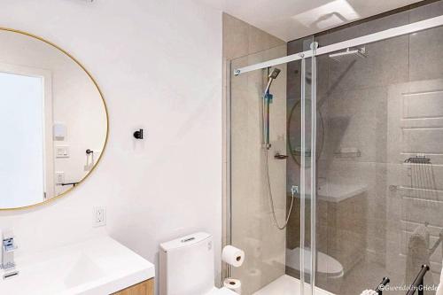 a bathroom with a shower and a toilet and a sink at Chalet Harmonia, Havre De Paix in Brownsburg