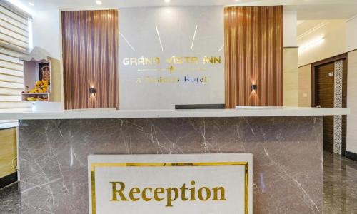 a reception desk with a sign in a lobby at Grand Vista Inn in Bengaluru